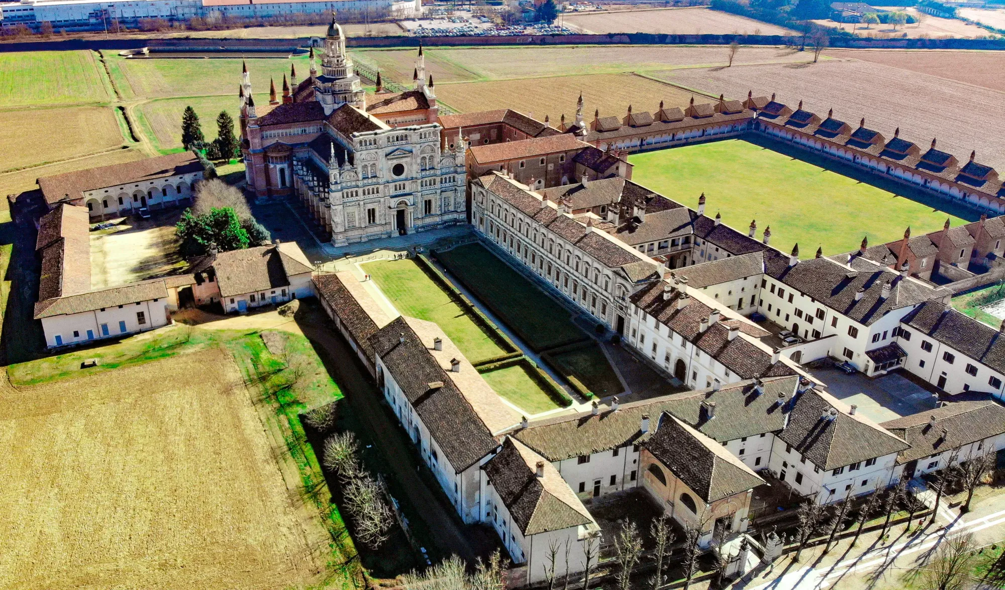 Aerial view of the Certosa di Pavia monastery complex surrounded by the flat fields of the Po Valley, Lombardy