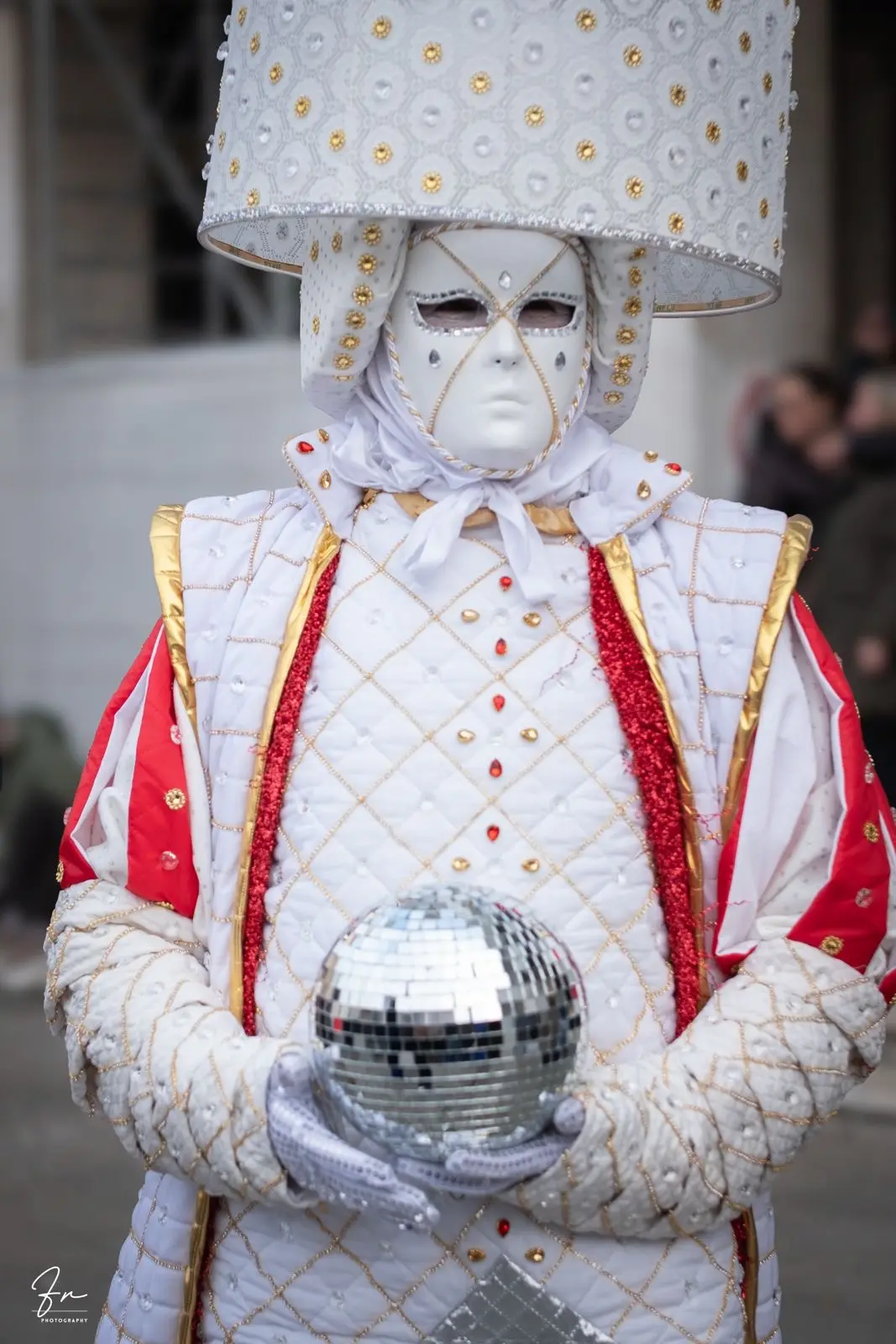Venice Carnival costume with a jewelled lampshade headdress, holding a mirrored disco ball